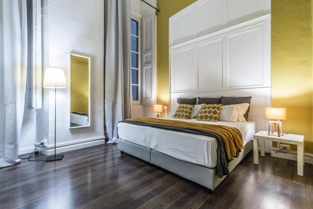 una camera con un letto e due lampade su un pavimento in legno di Family Apartments San Lorenzo a Genova