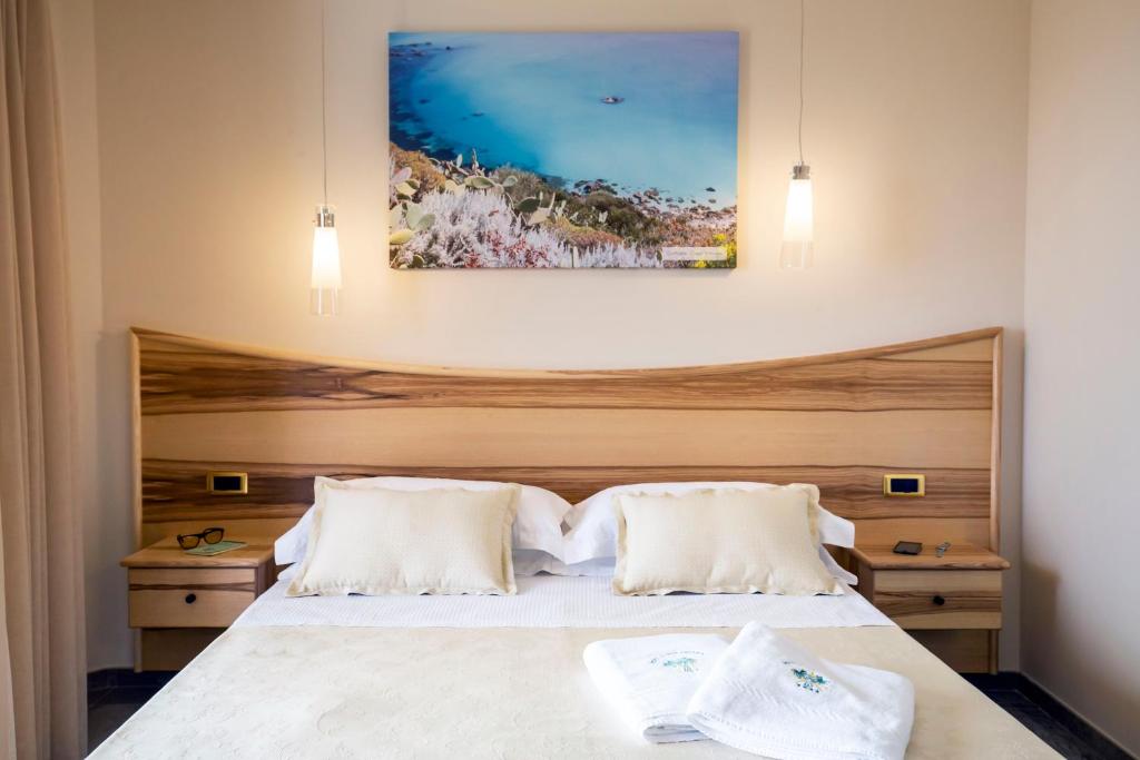 a bedroom with a large white bed with two pillows at Hotel Santa Chiara in Capo Vaticano