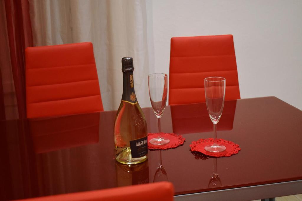 uma garrafa de vinho e dois copos numa mesa em Casa vacanza La Collegiata em Catânia