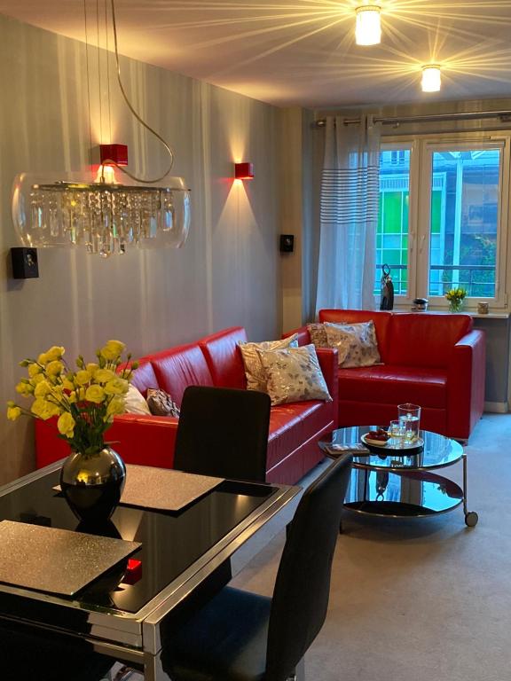 ワルシャワにあるGood Time Apartments - Warsaw Zgodaのリビングルーム(赤いソファ、テーブル付)