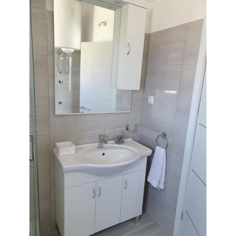łazienka z białą umywalką i lustrem w obiekcie Apartment Mate4 w Bibinje