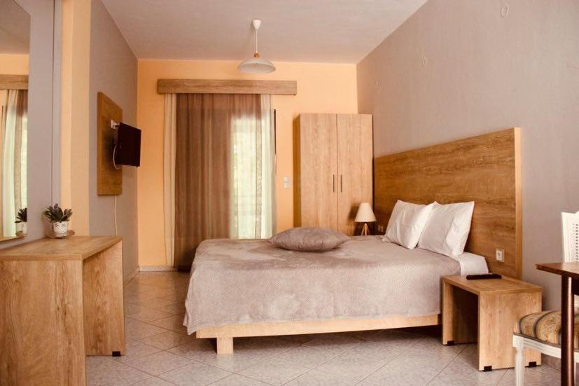 1 dormitorio con 1 cama grande y TV en Acherontas en Gliki