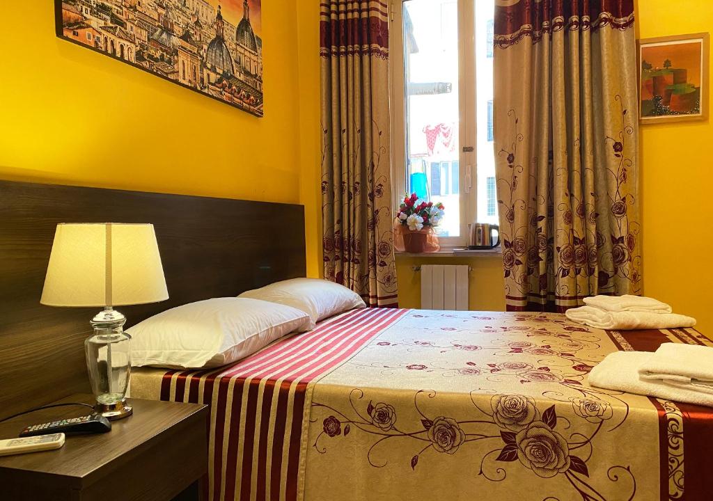 - une chambre avec un lit et une table avec une lampe dans l'établissement Sweet Dream Roma Termini, à Rome