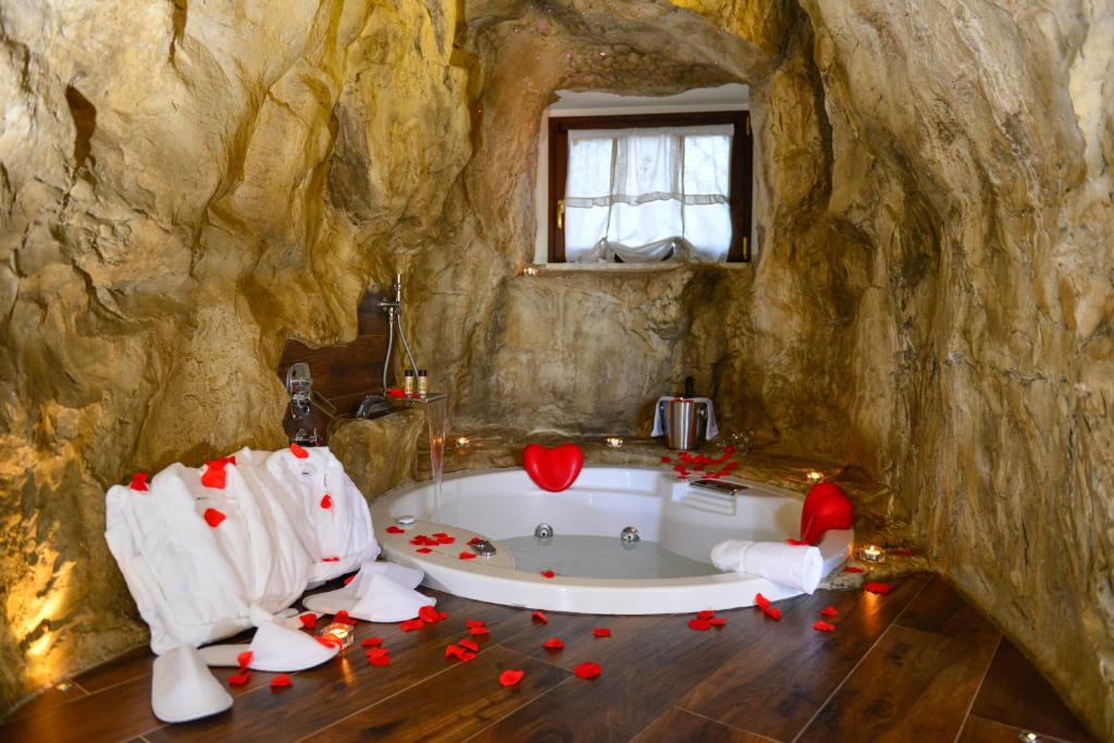 La salle de bains est pourvue d'une baignoire dans un mur de roche. dans l'établissement B&B La Casa nella Roccia, à Villanova del Battista