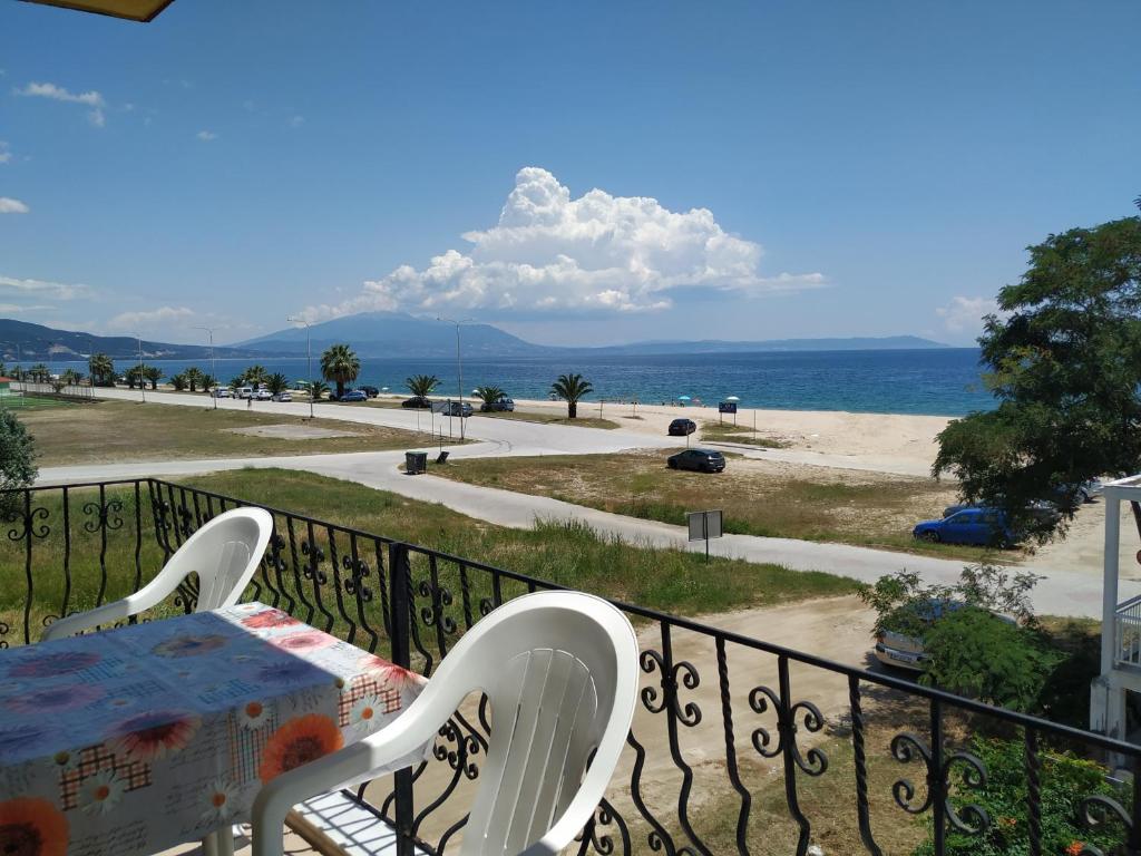 a balcony with a table and chairs and a view of the beach at Thomas Vrasna Close To The Sea in Nea Vrasna
