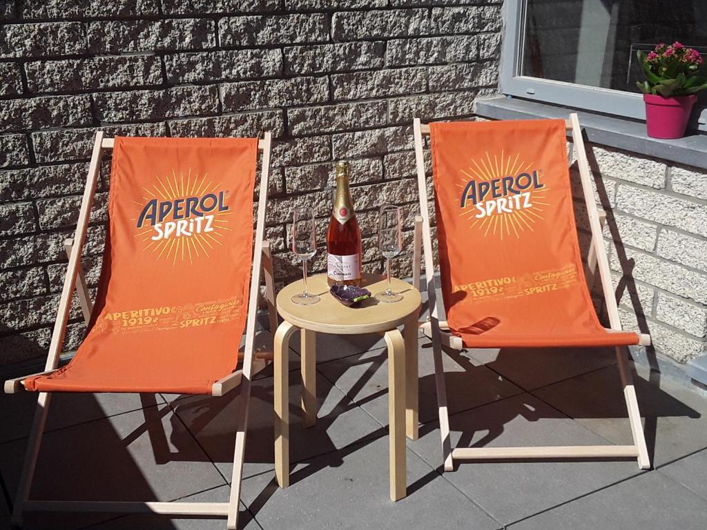two chairs and a table with a bottle of soda at Terrasses de Malmedy - Duplex 419 in Malmedy