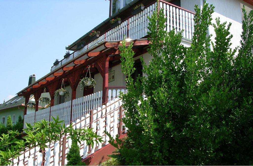 a house with a white and red railing at Relax Apartmanok in Zalakaros