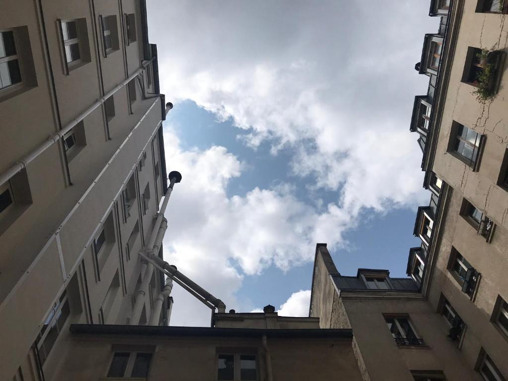 einen Blick auf den Himmel von zwei Gebäuden in der Unterkunft Studio - Central Paris in Paris