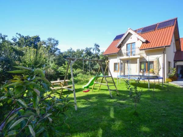 a yard with a playground in front of a house at Kwatery Prywatne Beata in Darłowo