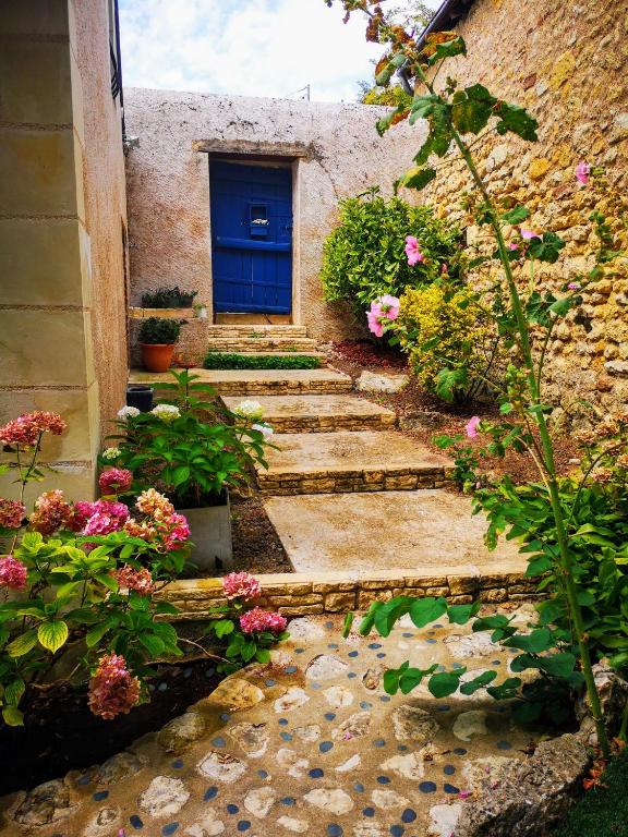 - un bâtiment en pierre avec une porte bleue et des fleurs dans l'établissement Closerie de l'Echeneau au cœur de Vouvray, à Vouvray