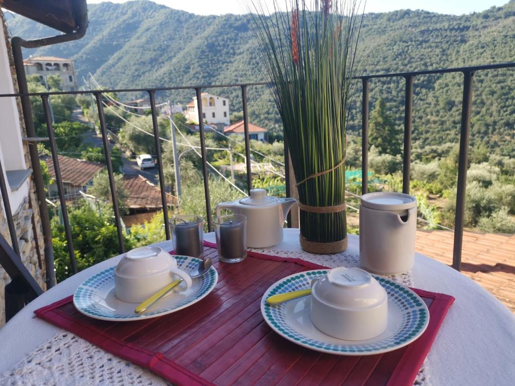 een tafel met borden eten op het balkon bij Casa Davide in Dolcedo