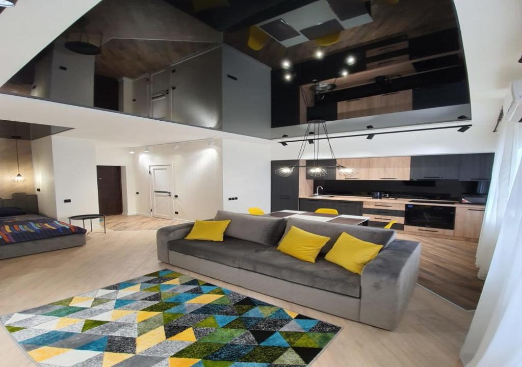 - un salon avec un canapé gris et des oreillers jaunes dans l'établissement New Lux apartment 2020, à Kharkov