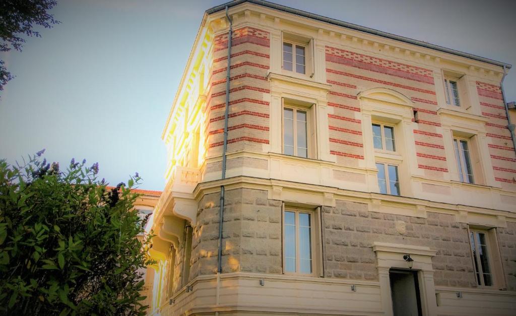 un gran edificio de ladrillo con el sol brillando en él en Chez Martine et Philippe en Velay, en Saint-Didier-en-Velay