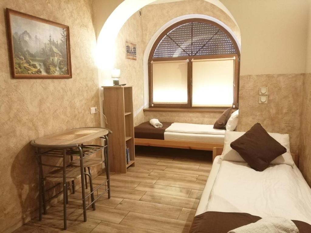 a room with a bed and a table and a window at Apartament i pokoje gościnne Gniezno in Gniezno