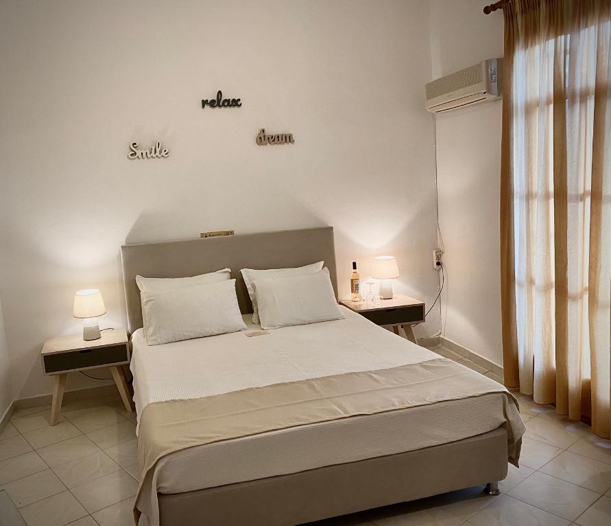 a bedroom with a large bed with two tables and two lamps at Asteri Hotel in Livadi