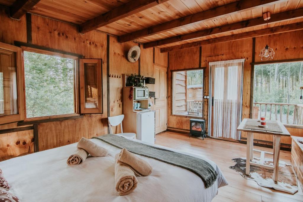 1 dormitorio con 1 cama grande en una habitación con paredes de madera en DURMIENDO ENTRE ARBOLES, Bonita cabaña en La Rioja, en Anguciana