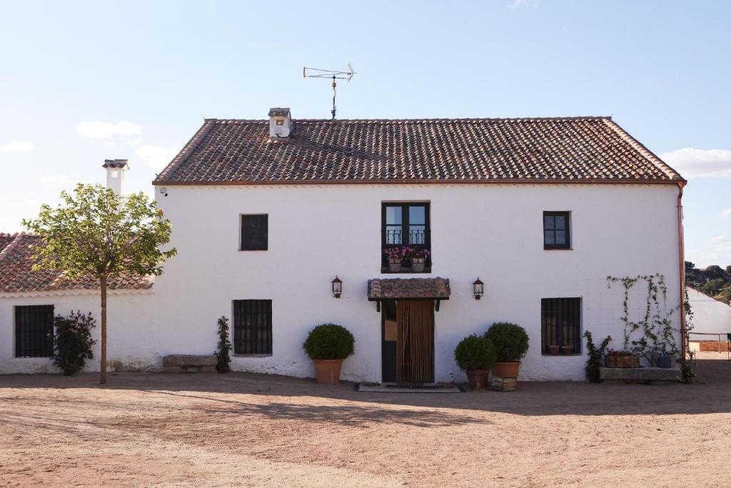 Casa blanca con techo marrón en Hotel Caserio Aldeallana en Segovia