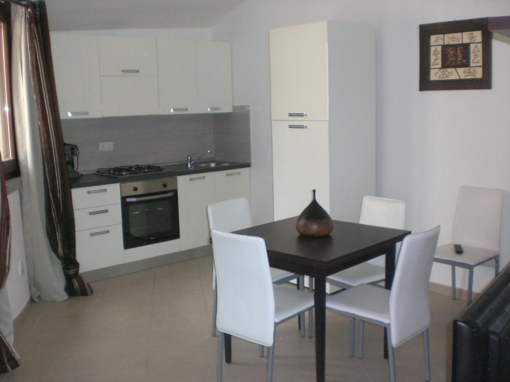 a kitchen with a black table and white chairs at Casa Malù in Pula