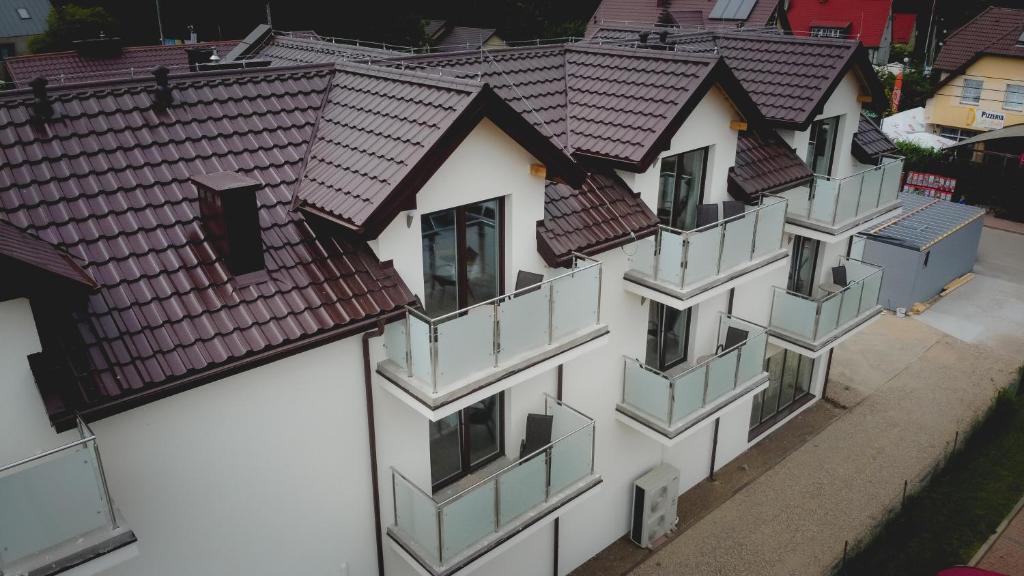 een luchtzicht op een wit gebouw met bruine daken bij Willa Mirella in Dębki