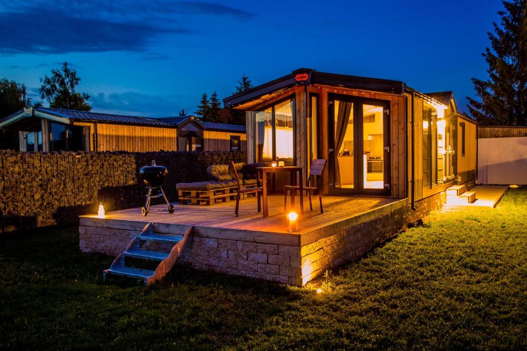 a tiny house with a deck in a yard at night at Fidelios Appartements in Pressath