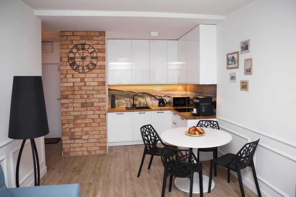 a kitchen and dining room with a table and chairs at Apartament Silva View in Hel