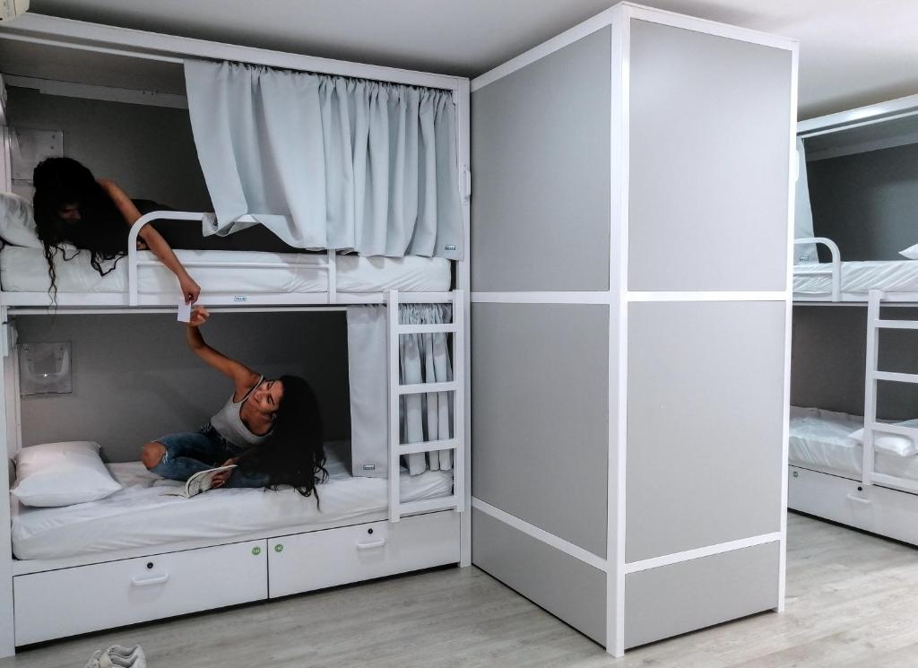 two girls are playing on their bunk beds at Alberguinn in Barcelona