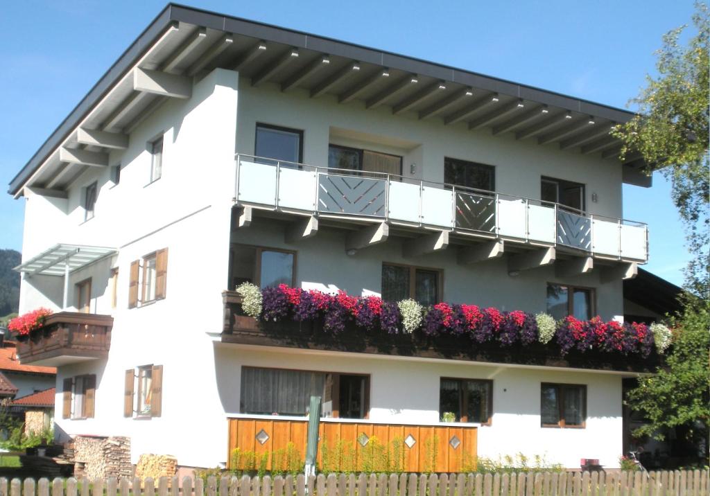 een wit gebouw met bloemen op de balkons bij Haus Margit in Kössen