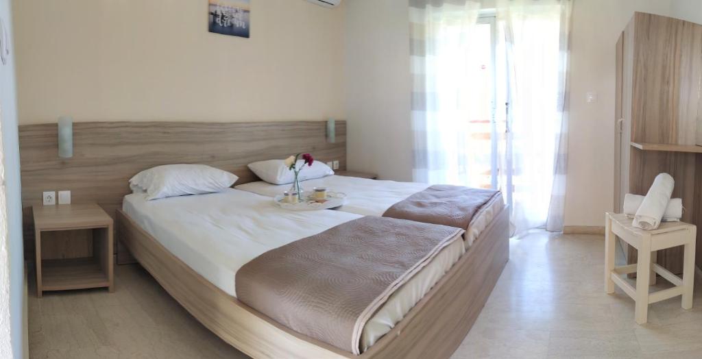 a bedroom with a large bed with a wooden headboard at Ever Green in Kavos