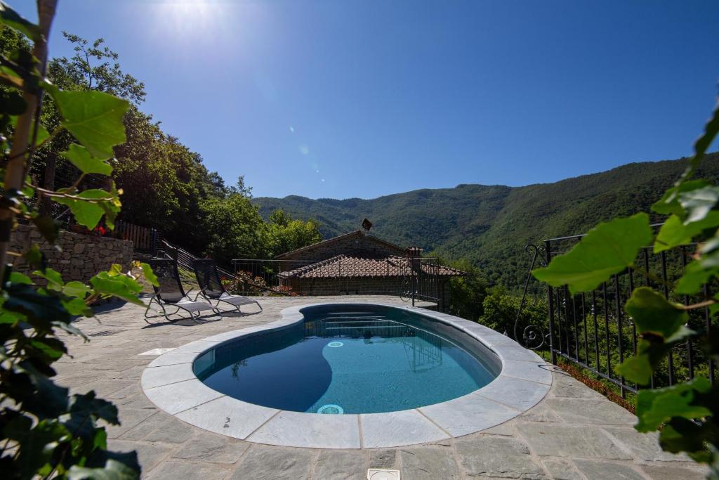 una piscina in un cortile con montagne sullo sfondo di Antichi Sentieri a Serravalle