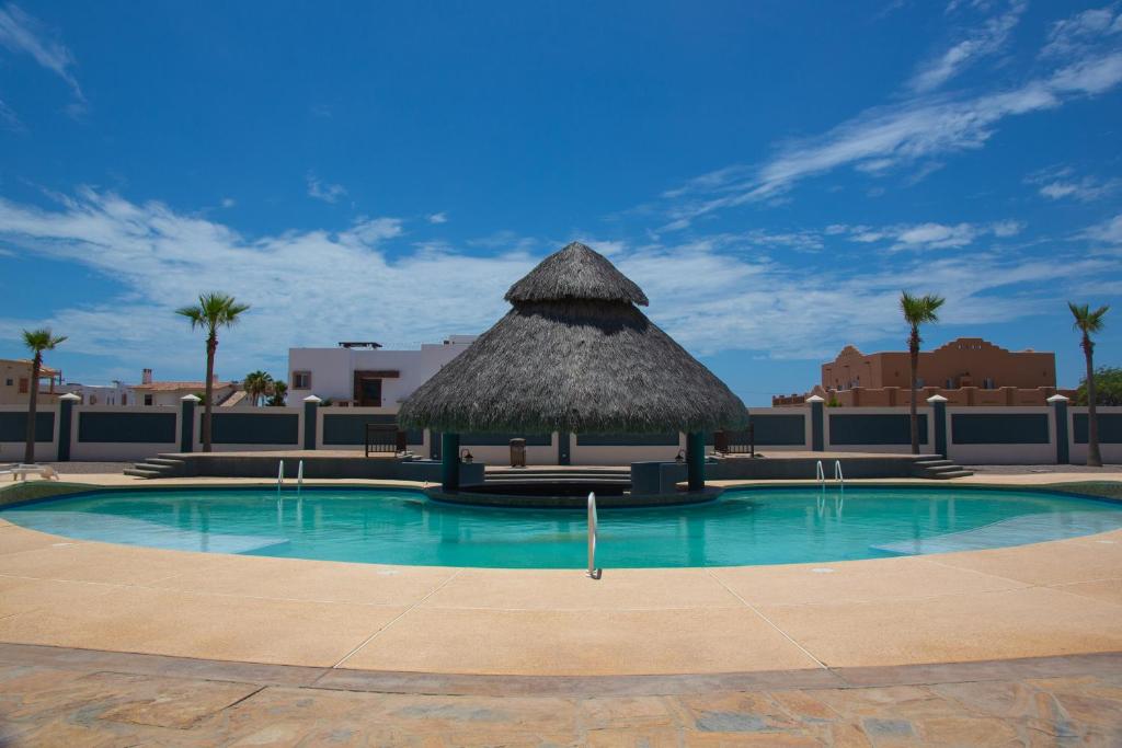 a large swimming pool with a thatch hut at Linda Vista 513 in Puerto Peñasco