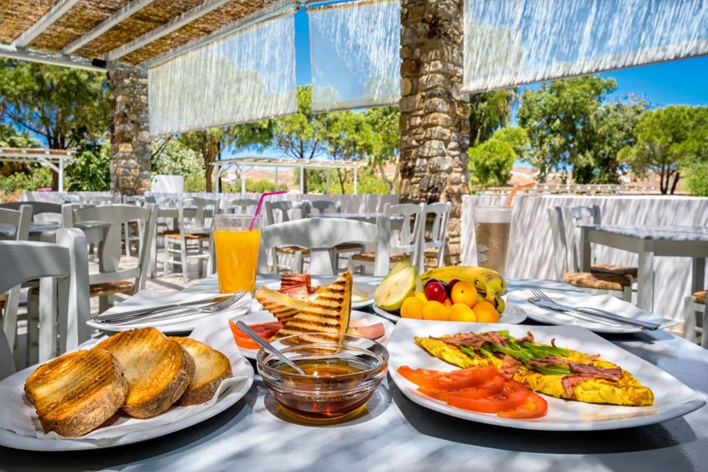 a table with two plates of food on it at Coralli Seaside Resort in Livadakia