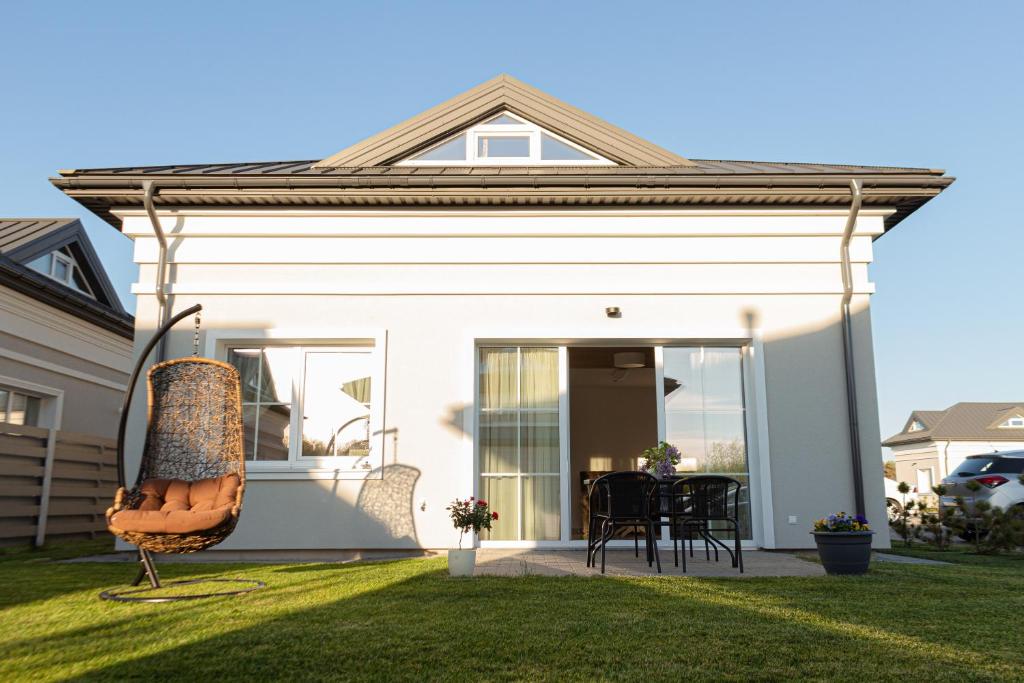 a house with a front porch with a patio at Vip VASARA in Palanga