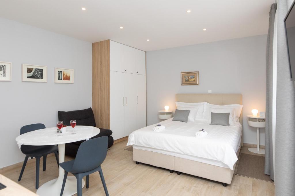 a bedroom with a bed and a table and chairs at Apartman Ružica in Pučišća