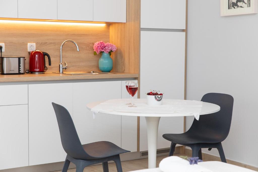 a kitchen with a white table and two chairs at Apartman Ružica in Pučišća
