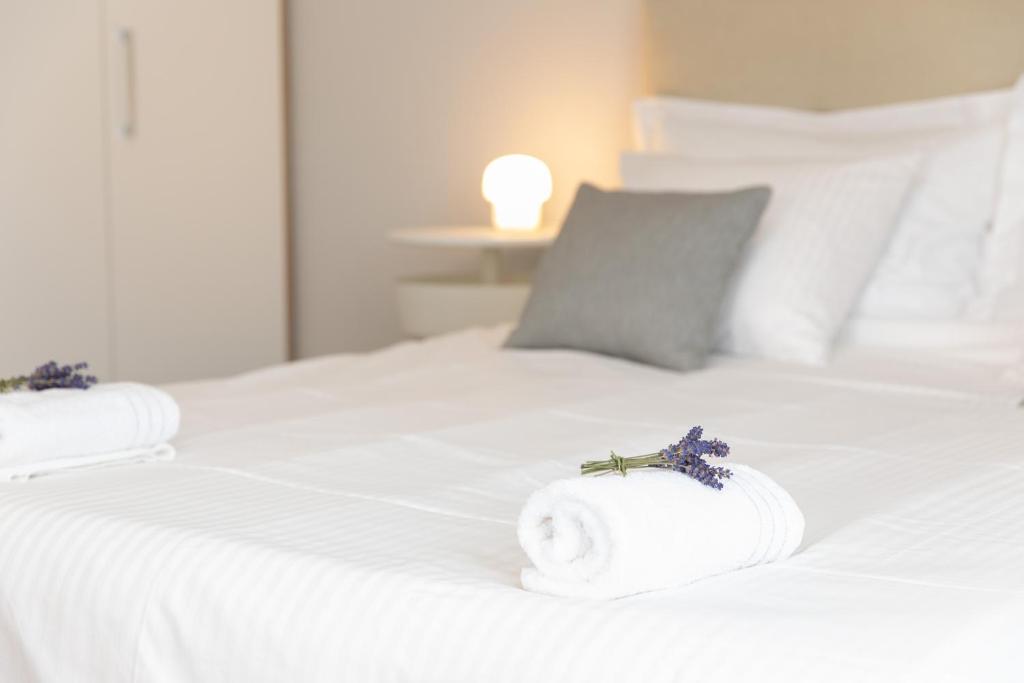 a white bed with two rolls of towels on it at Apartman Ružica in Pučišća