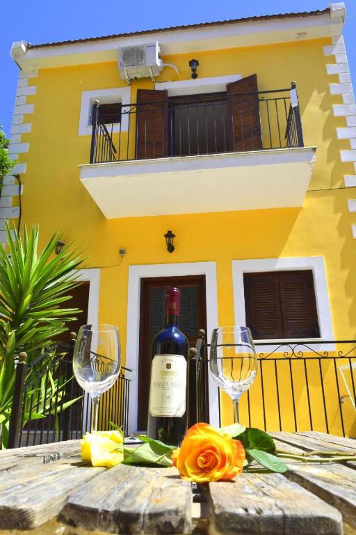 a bottle of wine sitting on a table with two glasses at Dourios Ippos Apartments in Frikes