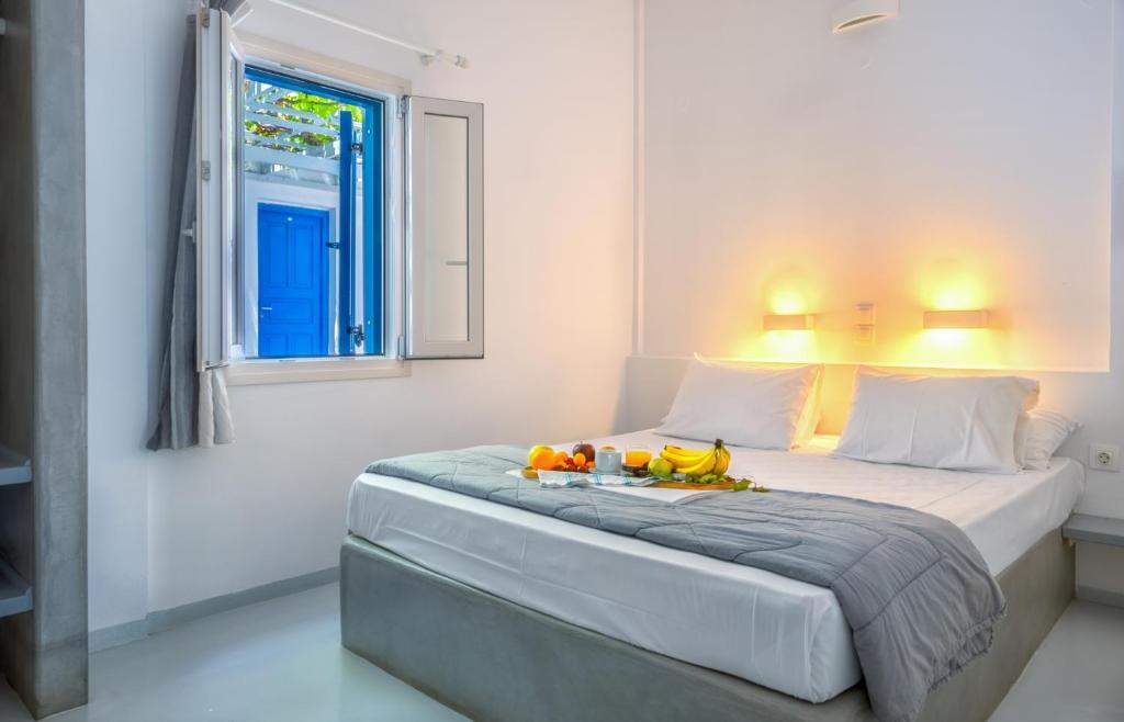 a bedroom with a bed with two fruit on it at Coralli Seaside Resort in Livadakia