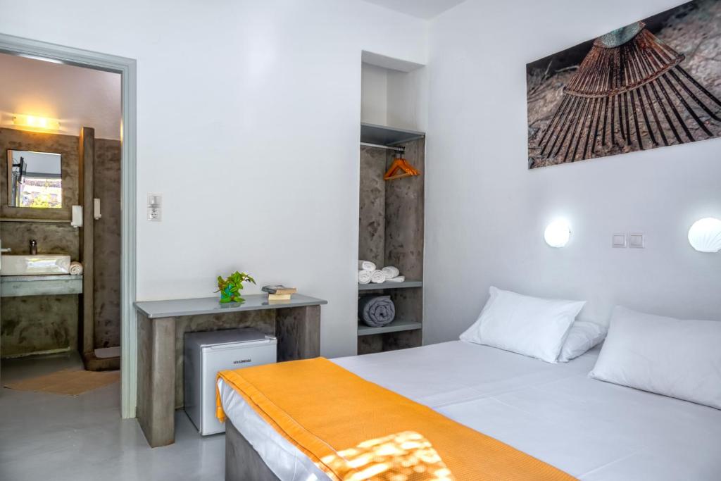a bedroom with a bed and a desk in a room at Coralli Seaside Resort in Livadakia