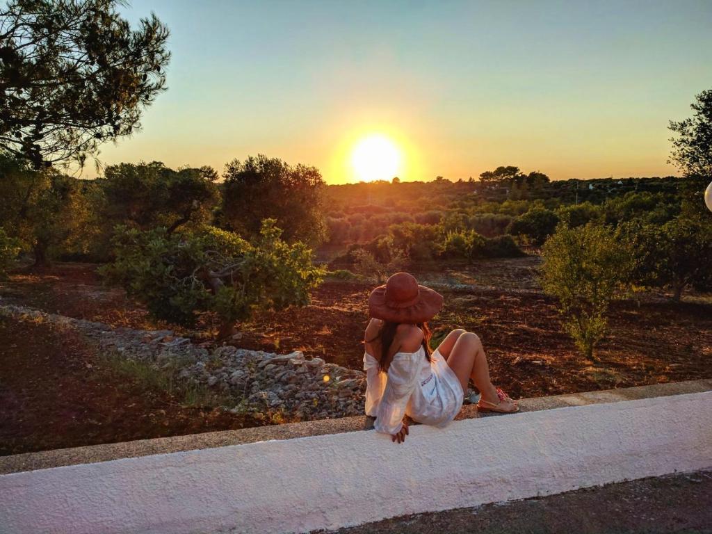 Eine Frau, die ein Kind hält, während sie den Sonnenuntergang sieht. in der Unterkunft Casa vacanze in Valle D'Itria in Ceglie Messapica