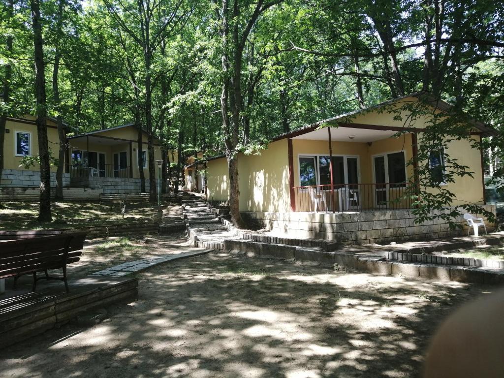 a house in the shade of trees at Ваканционно селище СБХ in Shkorpilovtsi