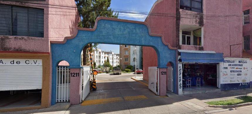 un edificio con un arco blu su una strada cittadina di Departamento centrico cerca de la feria a Aguascalientes