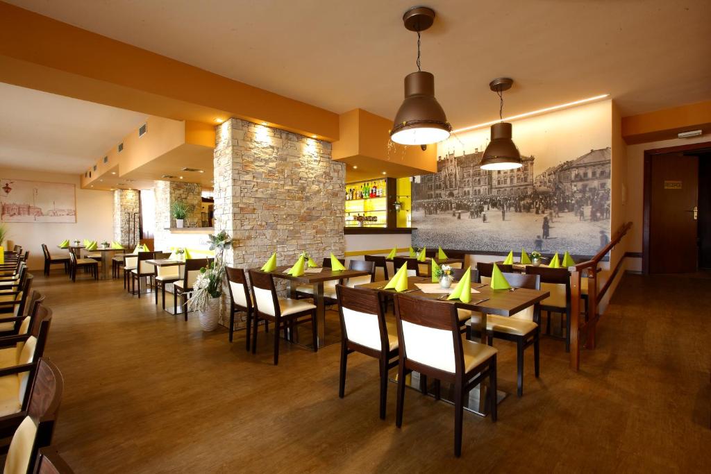 a restaurant with tables and chairs and a brick wall at Hotel Classic in Nový Bydžov