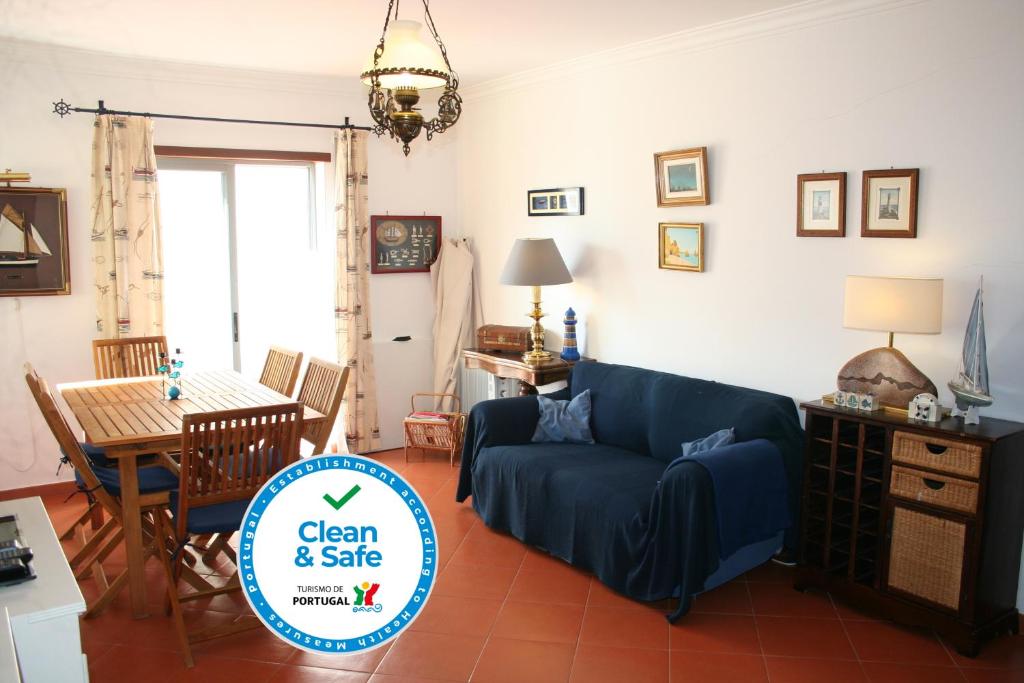 uma sala de estar com um sofá azul e uma mesa em Cezimbra Guest House em Sesimbra