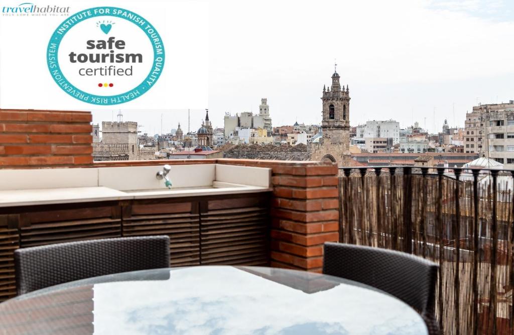 einen Balkon mit einem Tisch und Stühlen sowie Stadtblick in der Unterkunft Travel Habitat Ático Ciutat Vella. in Valencia