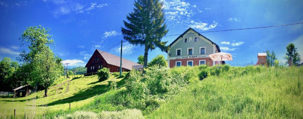 una casa y un granero en una colina de hierba en Penzion Dolní Morava, en Dolní Morava
