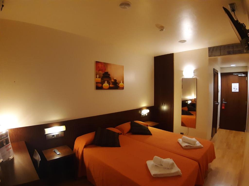 um quarto de hotel com duas camas com toalhas em Hostal Nirvana em Ponferrada