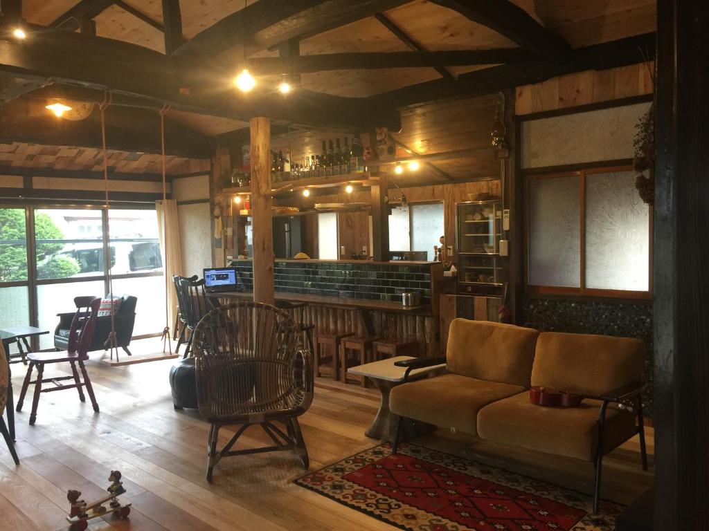 一棟貸し宿bochi-bochi في كوماغان: غرفة معيشة مع أريكة وبار