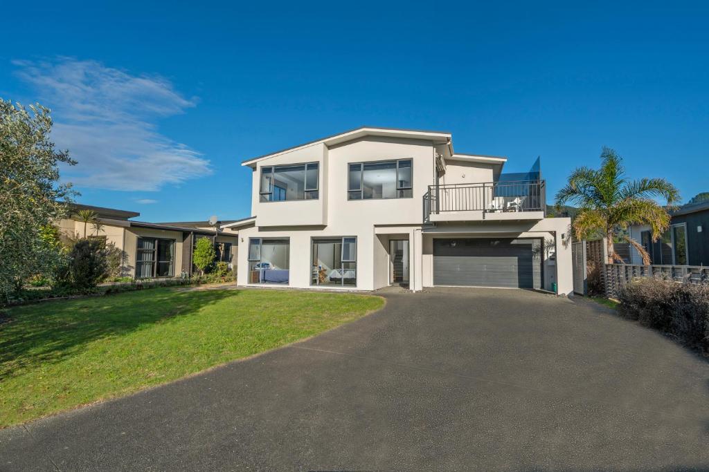 a large white house with a driveway at Pauanui Hangar Retreat - Pauanui Holiday Home in Pauanui
