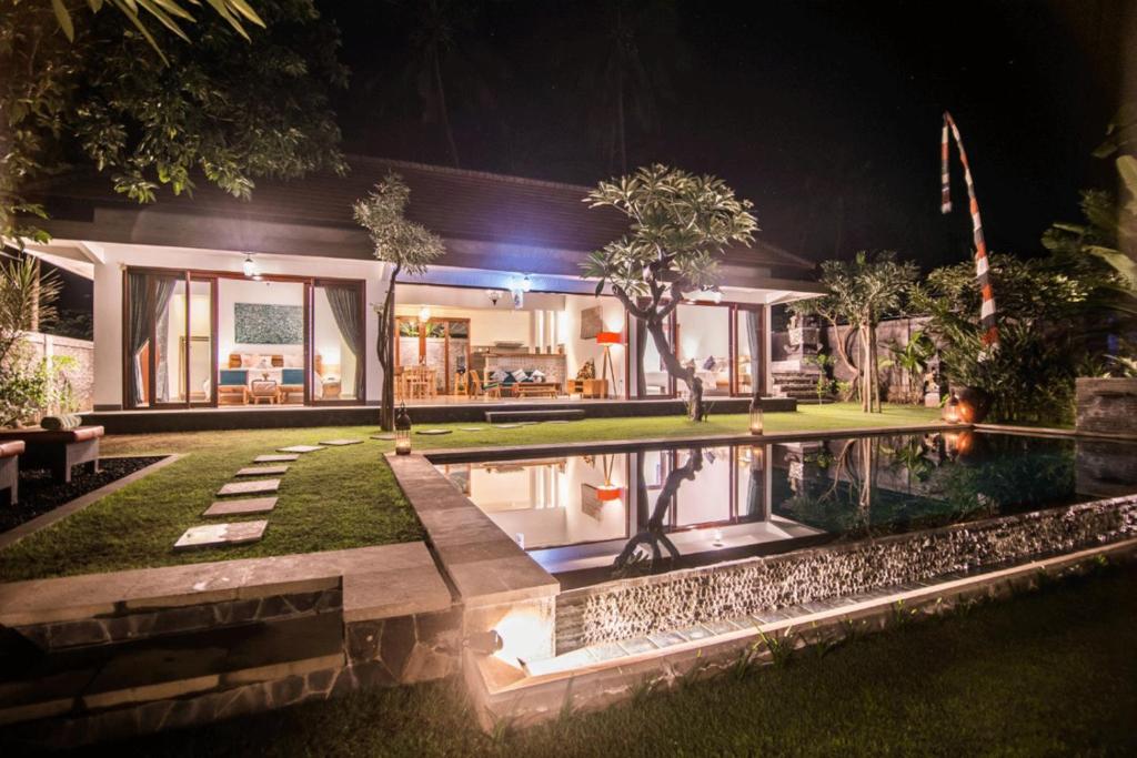 a house with a swimming pool at night at Villa Madja in Singaraja