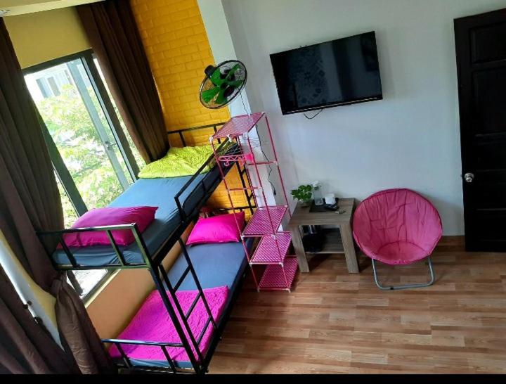 ダナンにあるHomestay Xì Trumのピンクとブルーの二段ベッド、薄型テレビが備わる客室です。